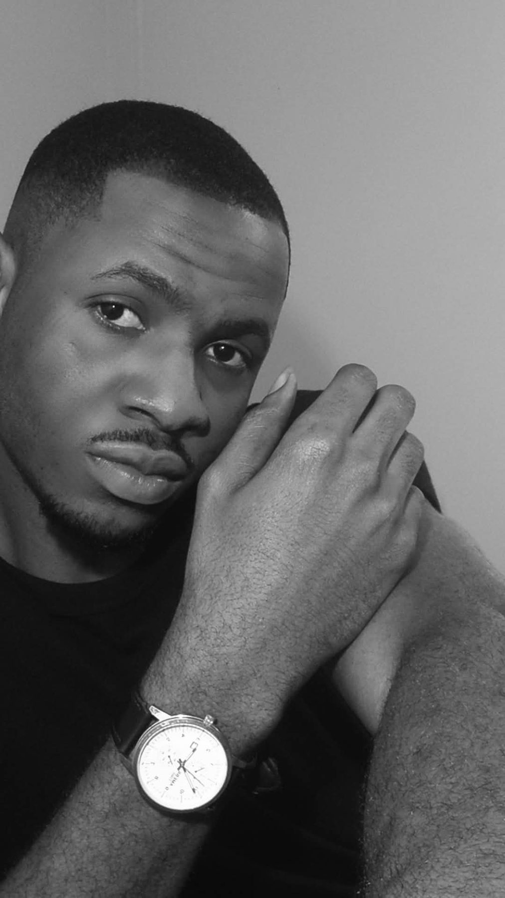 A black-and-white portrait of me, hand resting against my face.